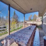 Back porch with large table and hot tub